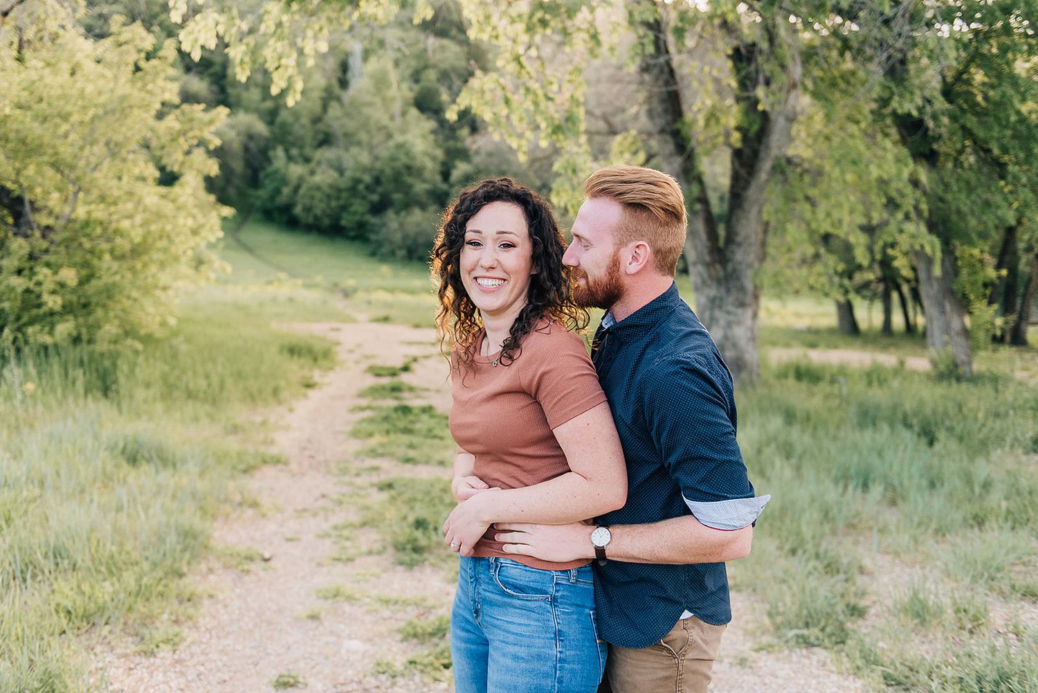 Couple sharing joyful laughter together on a nature trail.