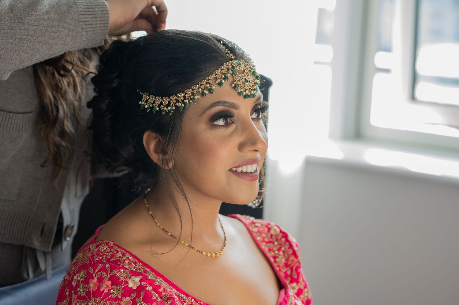 indian bride's hair being done on wedding morning