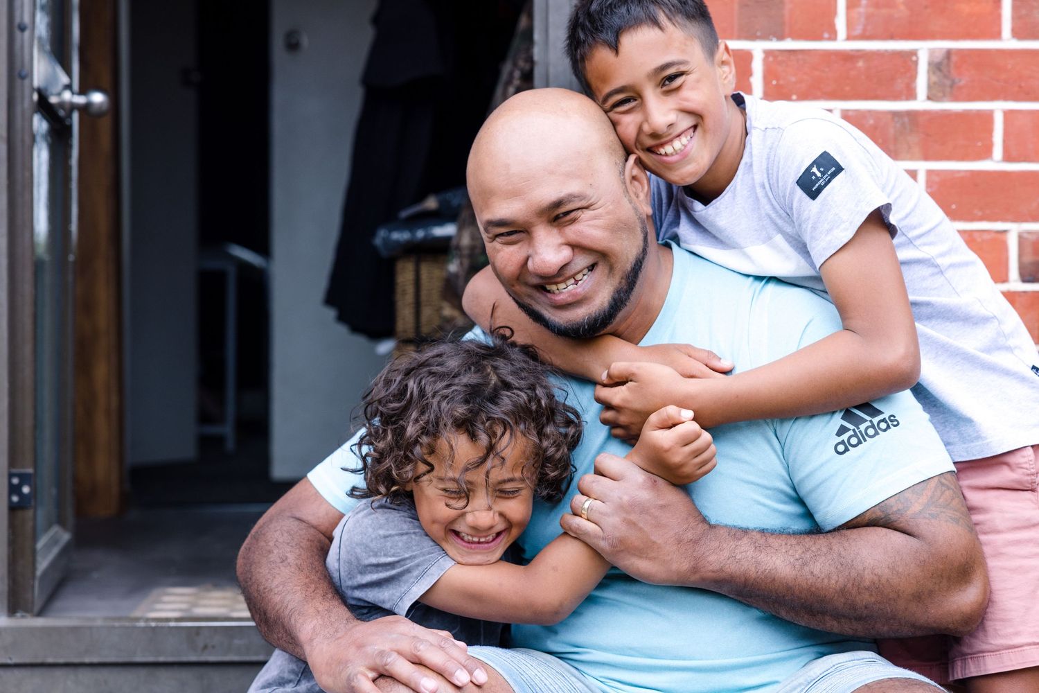 Joyful family moment captured on the doorstep of their home.