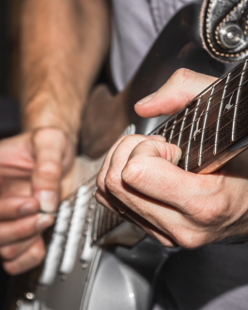close up of man playing electric guitar
