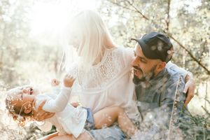 Sun-drenched family portrait session in a natural outdoor setting.