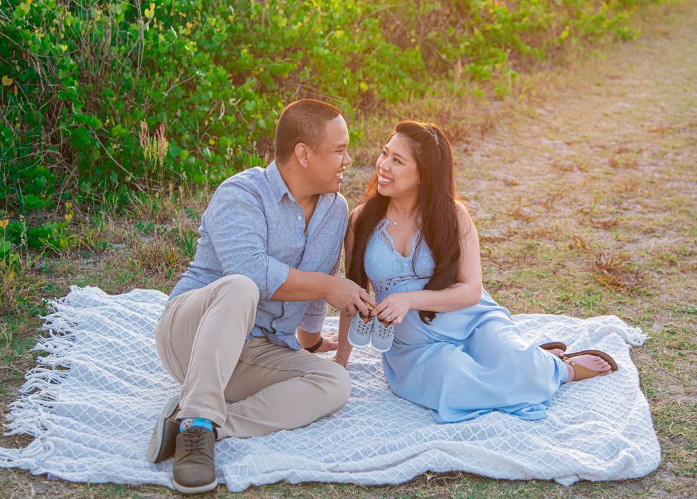 A romantic picnic scene on a white blanket surrounded by greenery during golden hour.