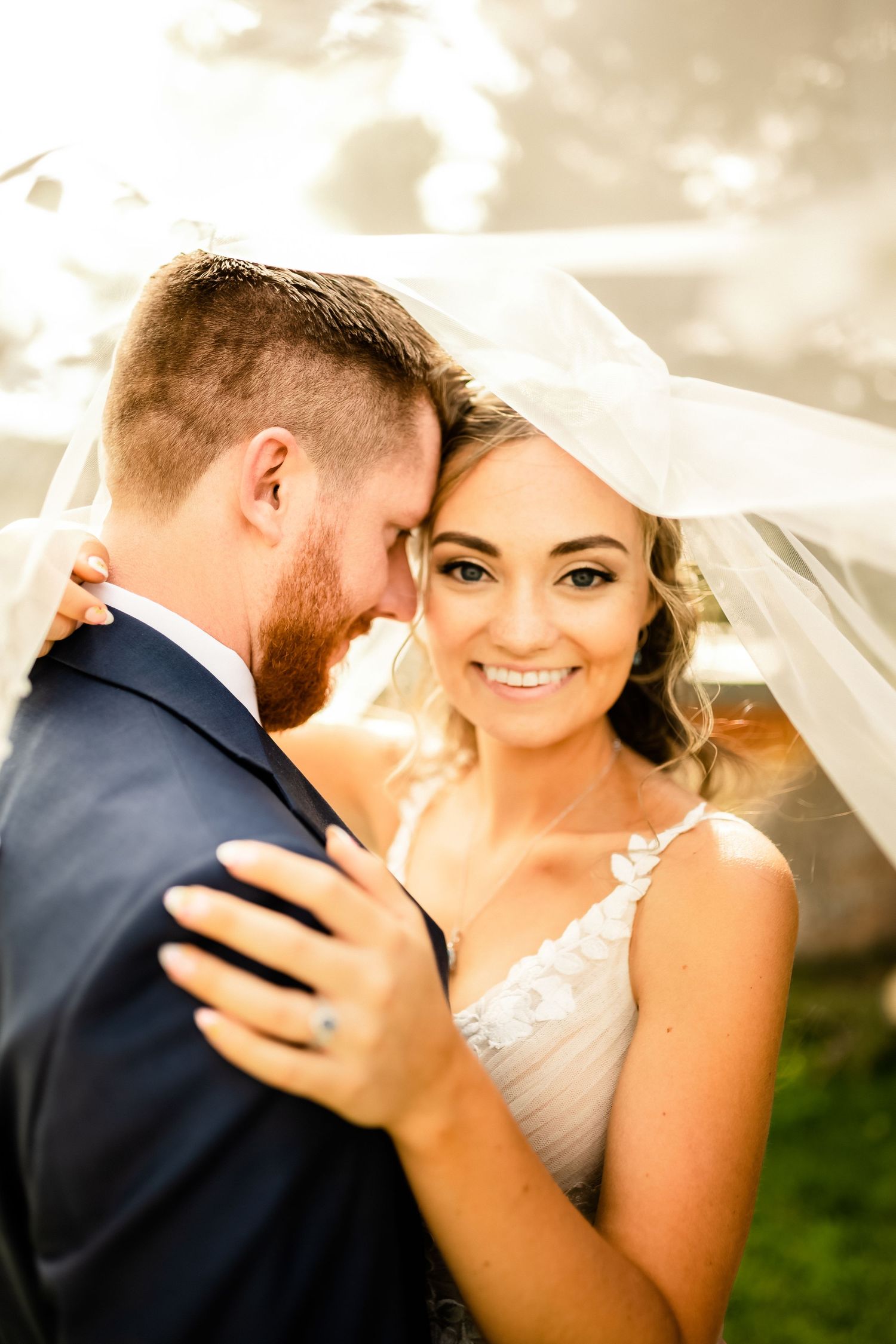 A tender wedding moment captured in warm sunlit tones.