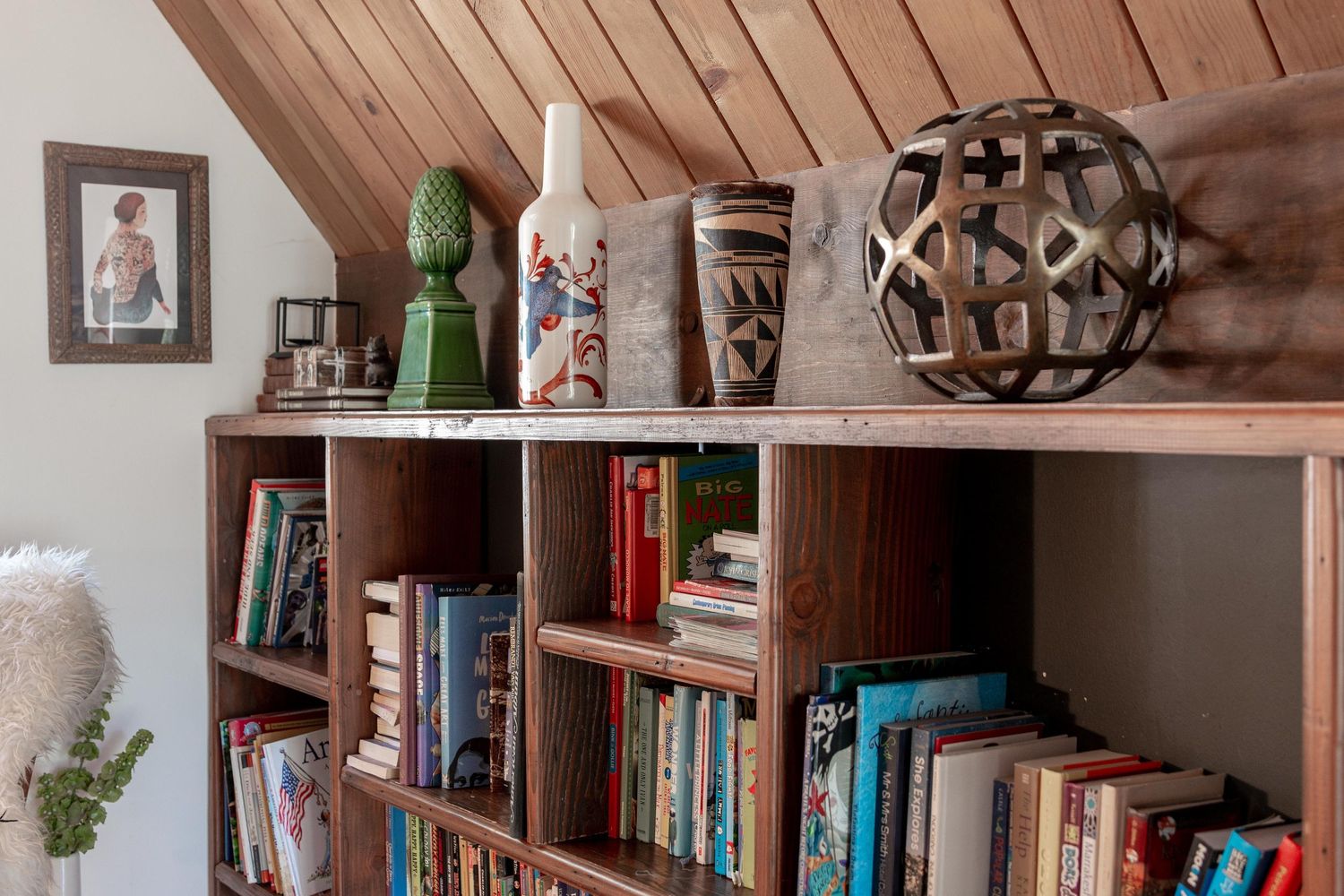 Cozy home library with wooden bookshelves, antique decor, and natural lighting from windows.