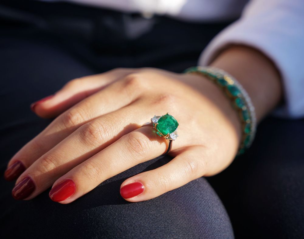Close-up shots of hands wearing elegant rings and red nail polish.