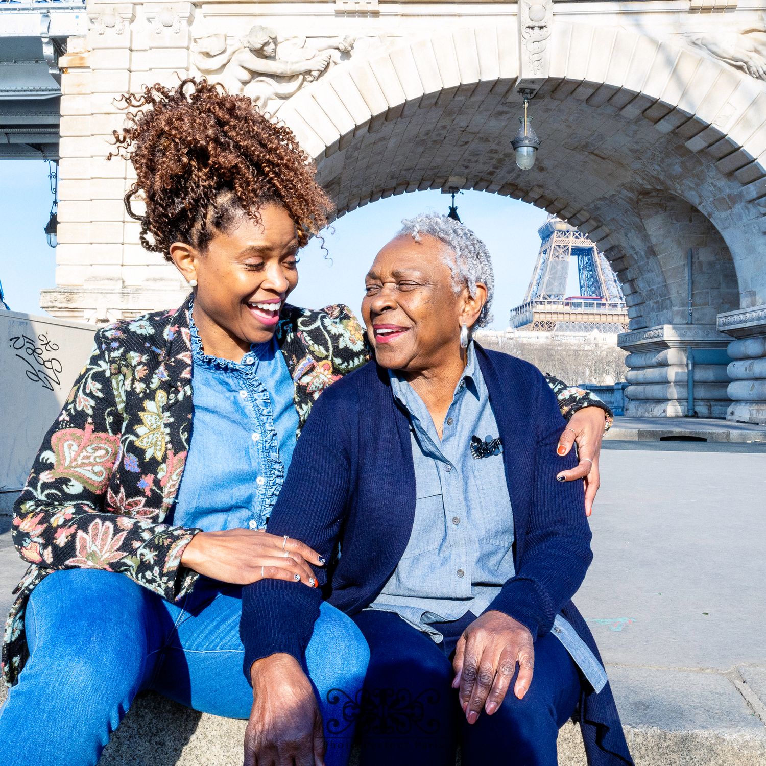 Mother and Daughter posing in front of the Eiffel Tower on a sunny day