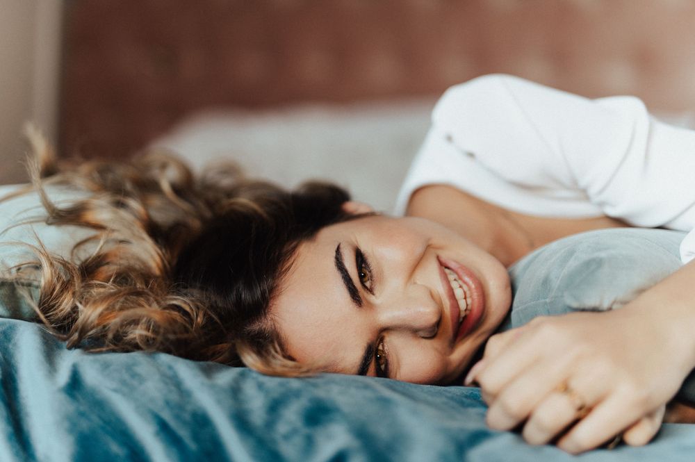 Couple lying on a couch sharing intimate laughter and joyful moments together.