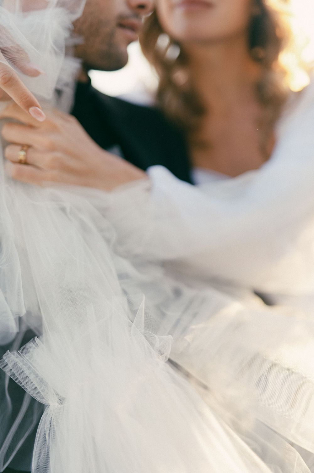 Close-up shot of romantic moment with flowing white tulle fabric.