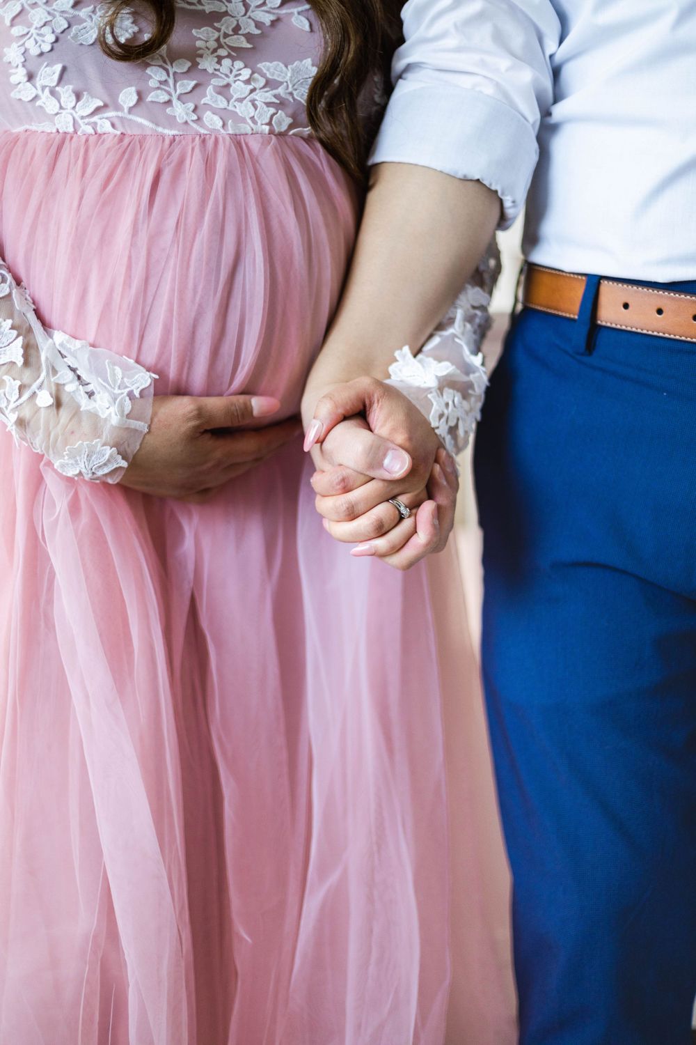 Detail shots of couple holding hands, with pink tulle dress and blue suit.