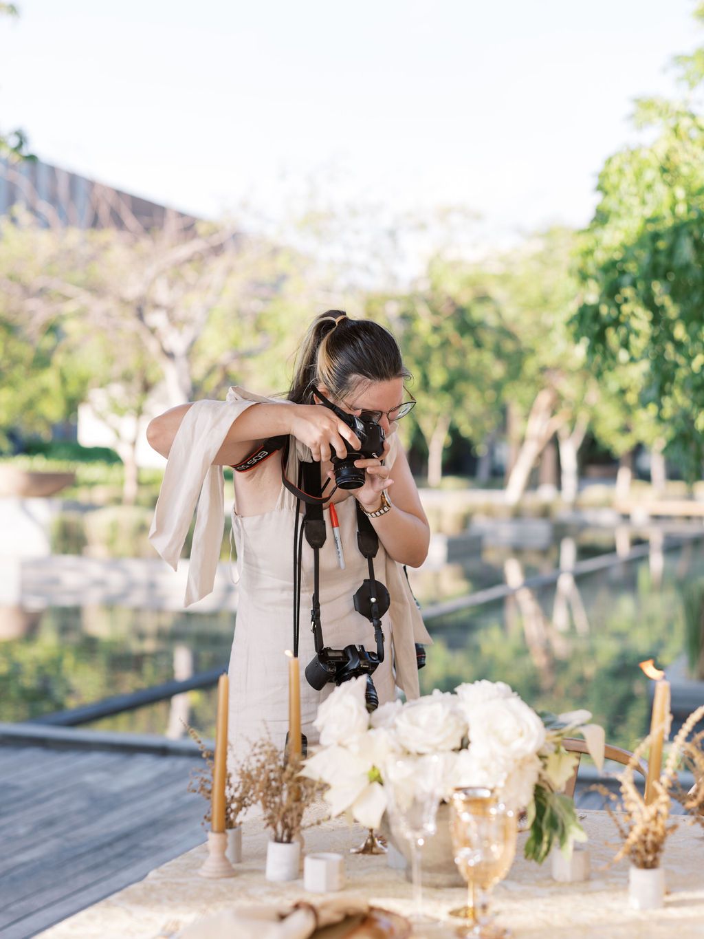 Photographer wearing casual clothes working with equipment at outdoor table setting.