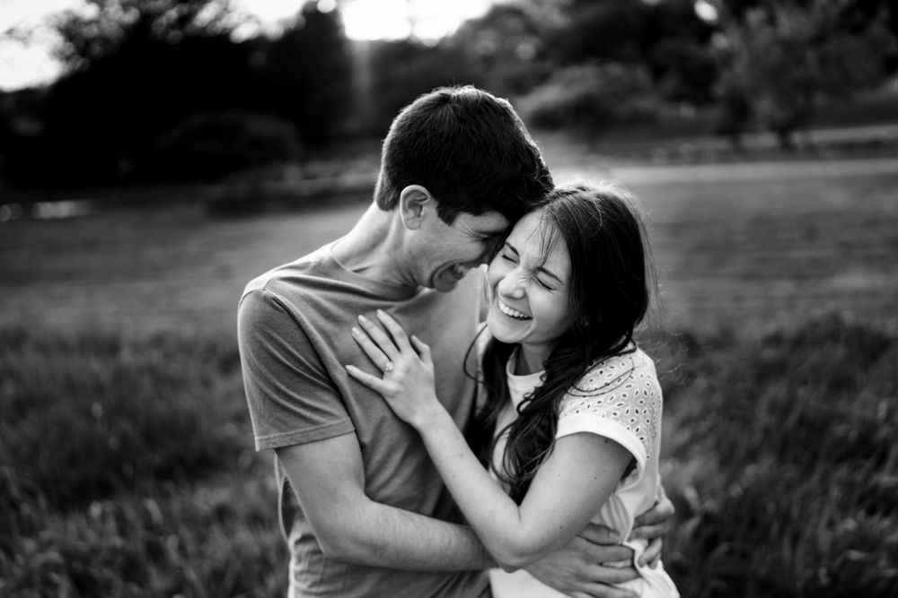 Intimate black and white portrait of a couple sharing a tender moment outdoors.