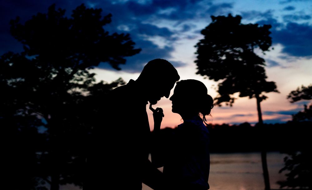 Dramatic silhouettes against a deep blue twilight sky create a romantic mood.