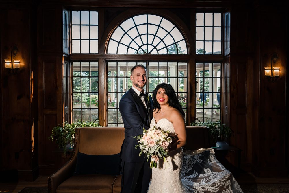 Elegant wedding portrait in historic venue with arched windows and natural light.