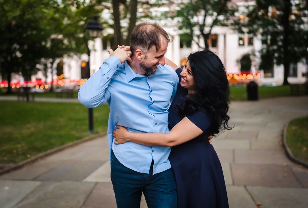 Romantic urban engagement session along city sidewalk.