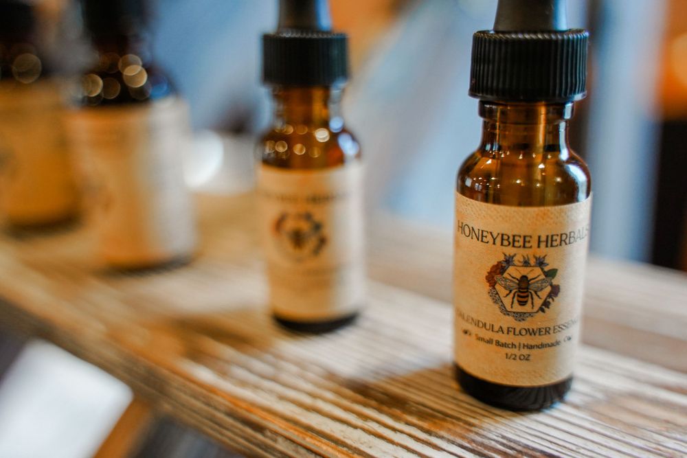 Amber glass essential oil bottles with dropper caps on wooden surface.