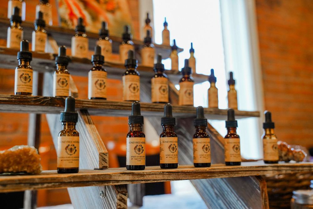 Display shelf with amber glass dropper bottles arranged in neat rows against exposed brick wall.