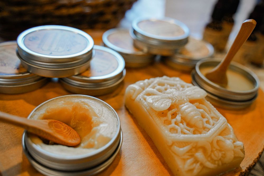 Mason jars and handcrafted soap display on warm wood surface.