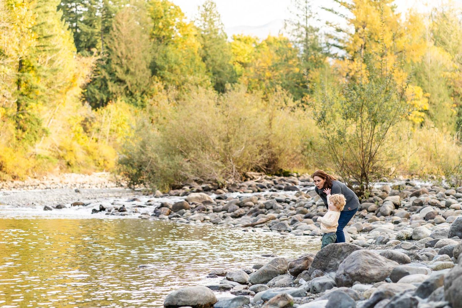 Mother watching son throw rocks at Tanner Landing Park.