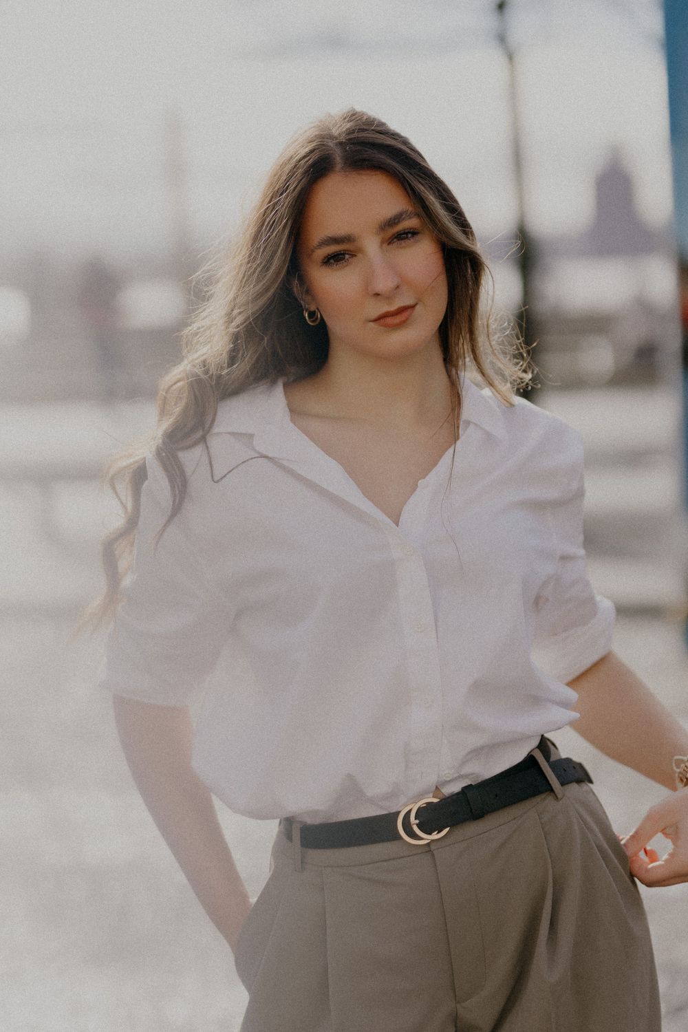 A fashion portrait showcasing a classic white button-down shirt paired with olive pants and a black belt.