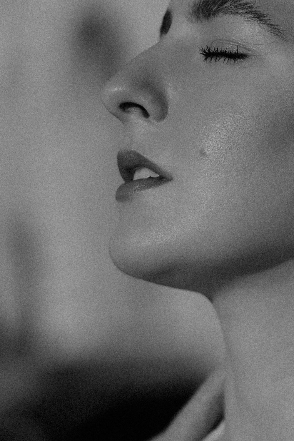 Artistic black and white close-up profile shot focusing on facial features and expression.