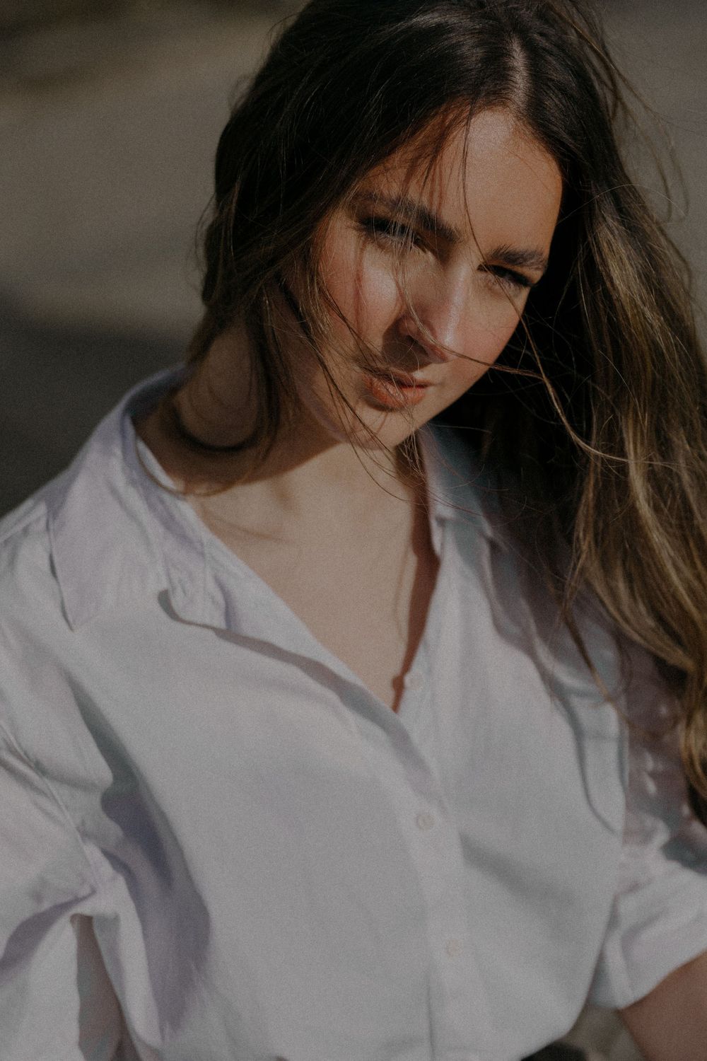 Candid outdoor portrait with sunlight illuminating a white button-down shirt.