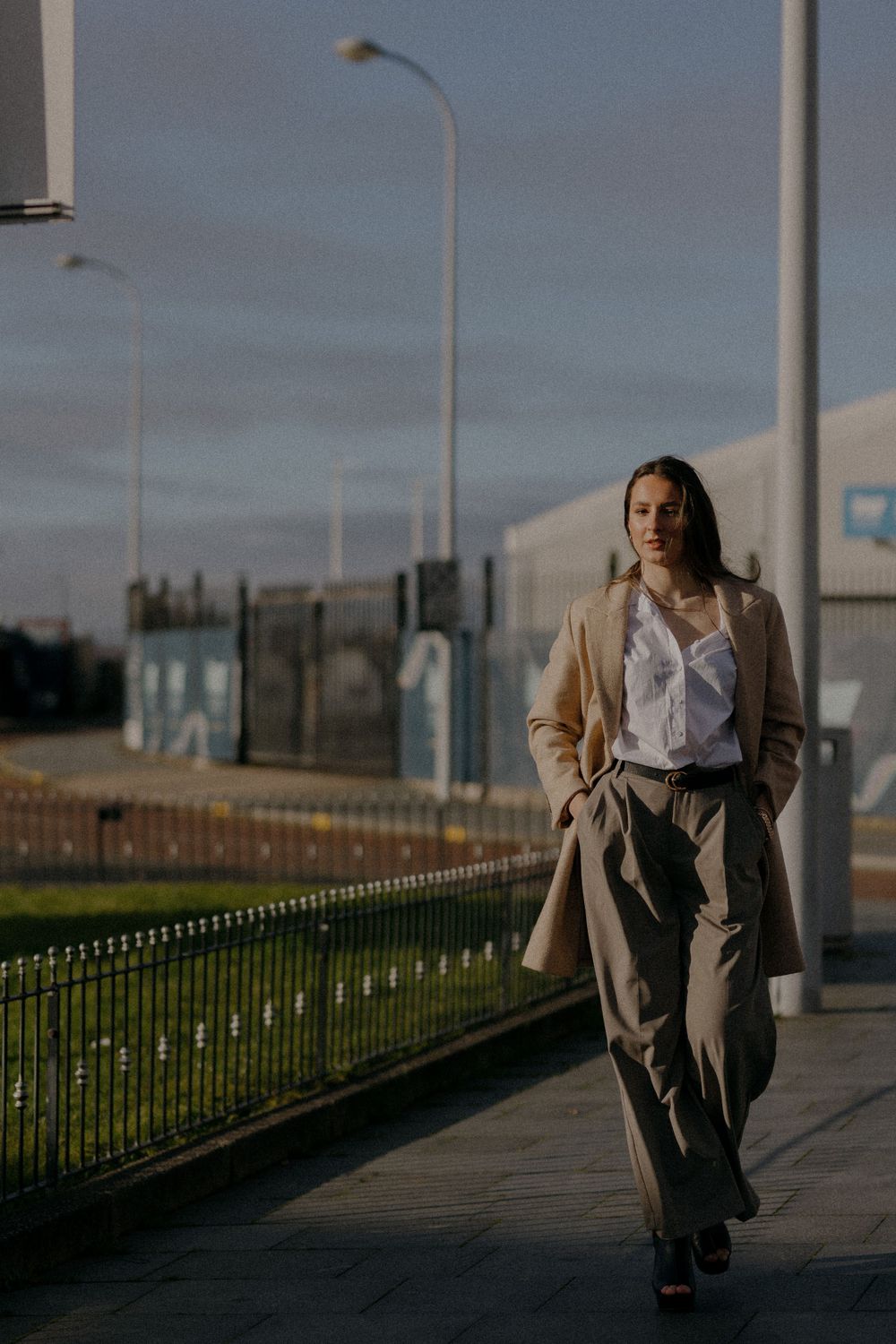 Evening street photography showing a figure walking along an illuminated pathway.