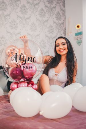 Celebratory scene with personalized bubble balloon, white balloons, and damask wallpaper background.