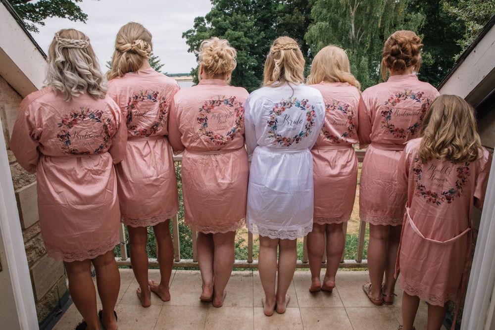 A group wearing matching pink robes with decorative designs on the back.