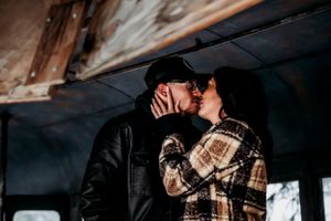 A romantic moment unfolds inside an old bus during a winter engagement photoshoot.
