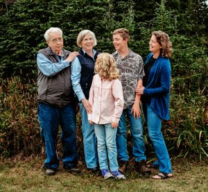 A casual family photo outdoors with everyone gathered close together against a natural backdrop.