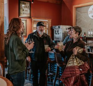 People having a conversation in a casual restaurant setting with wooden decor.