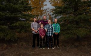 Group portrait in front of evergreen trees with autumn colors.