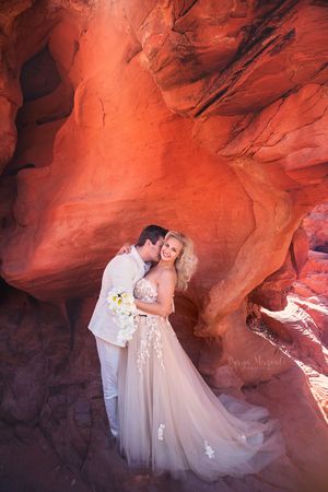 Intimate wedding moment captured inside a natural red rock cave formation.