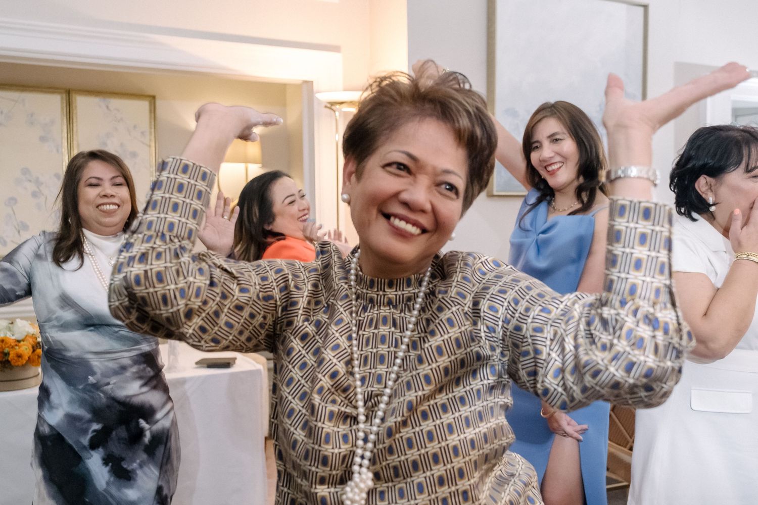 Woman with short hair smiles and dances at a London wedding reception.