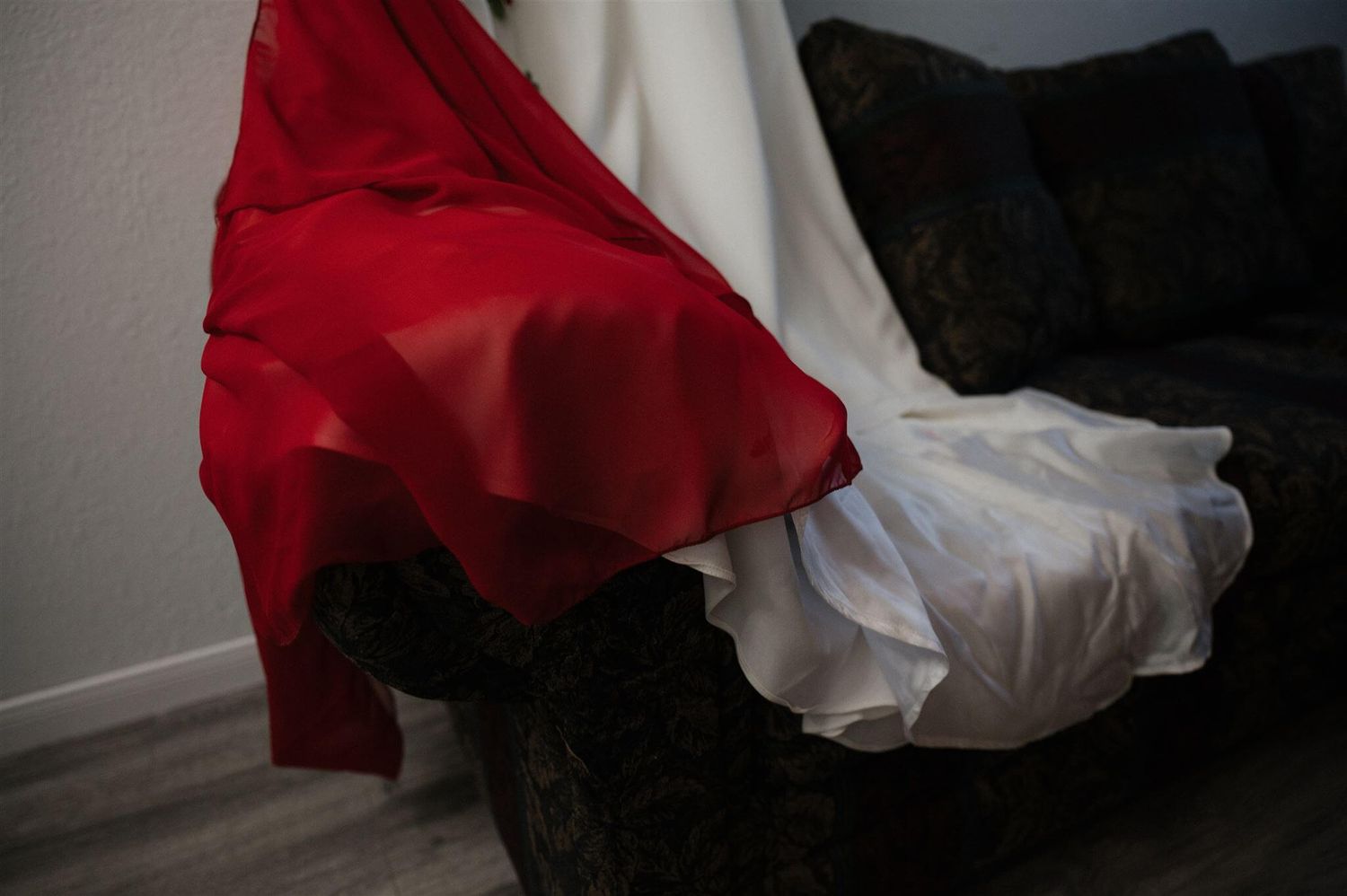Dramatic contrast of red and white fabric draped over a dark couch.
