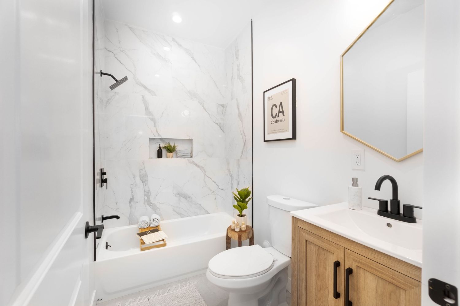 Modern bathroom featuring marble walls, black fixtures, and wooden vanity with clean minimalist design.