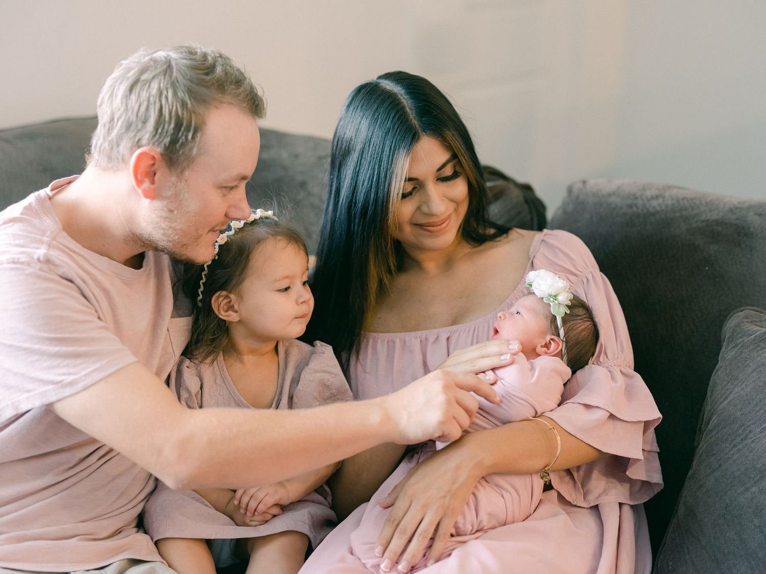 mom, dad, sister are looking at their newborn baby girl in Centerville, Utah.