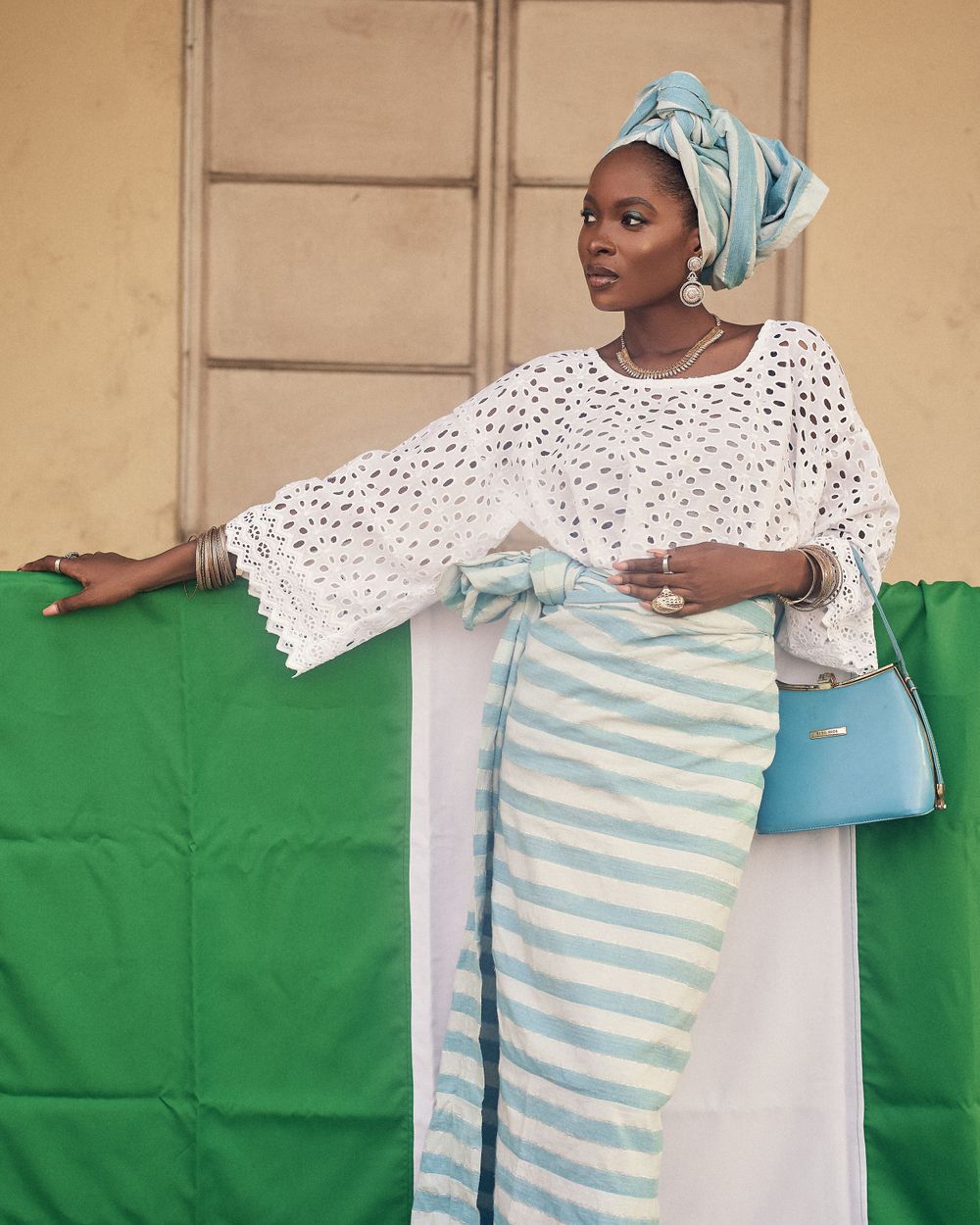 A stylish pose in white crochet sleeves and striped skirt against green backdrop.