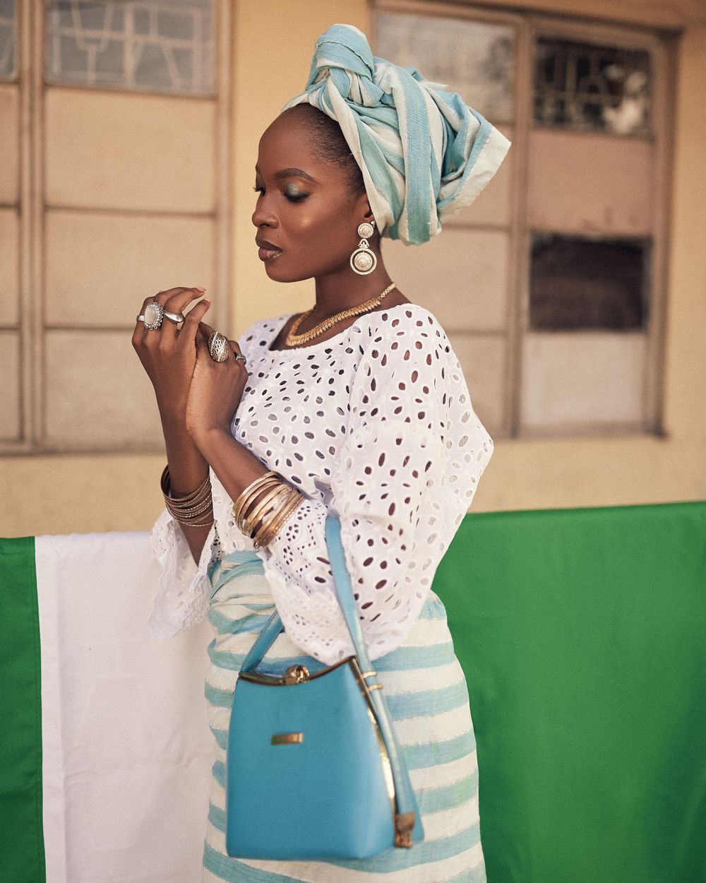 Stylish outfit featuring white eyelet blouse, turquoise headwrap and striped skirt with matching handbag.