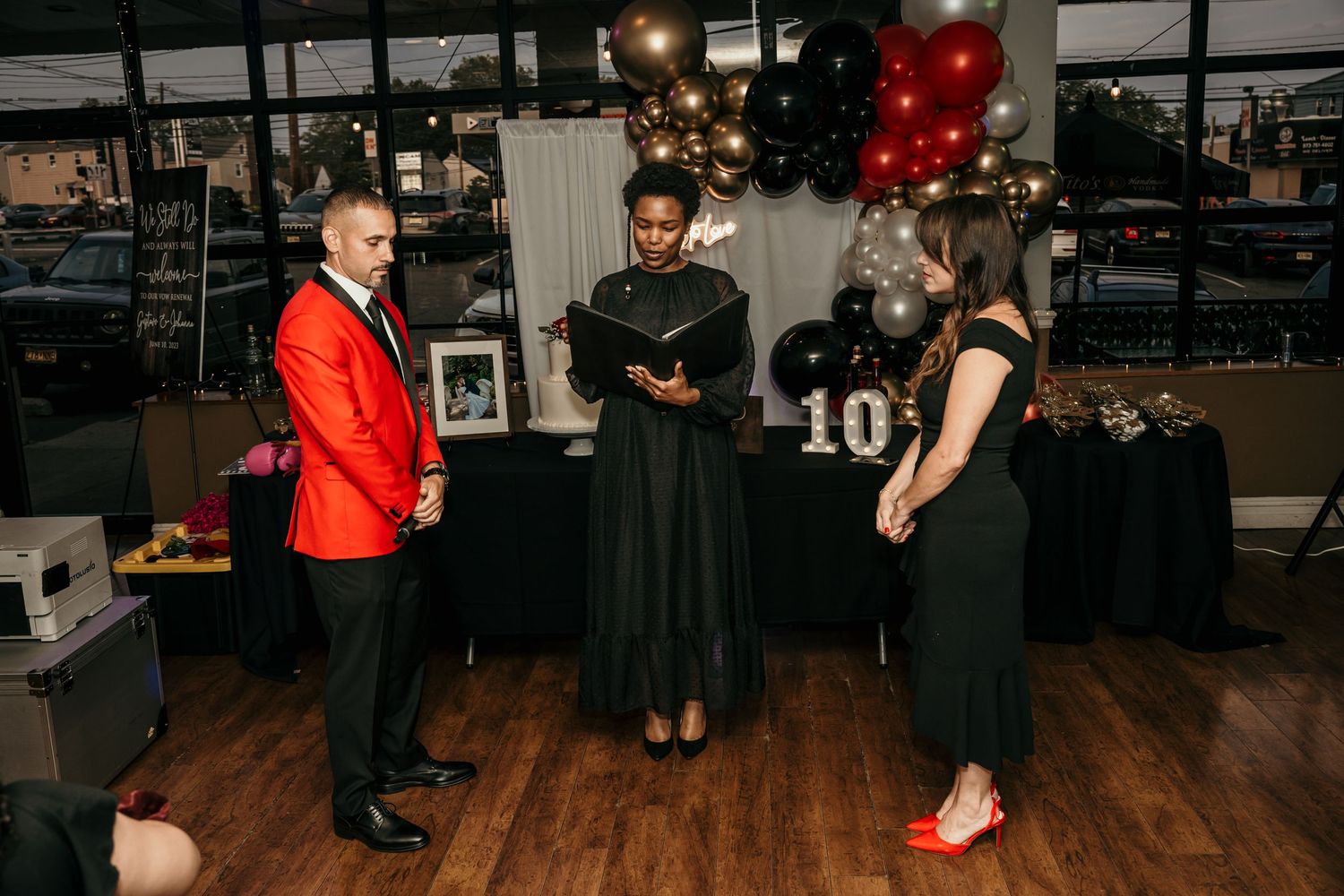 A festive party venue decorated with red and gold balloons for a celebration.