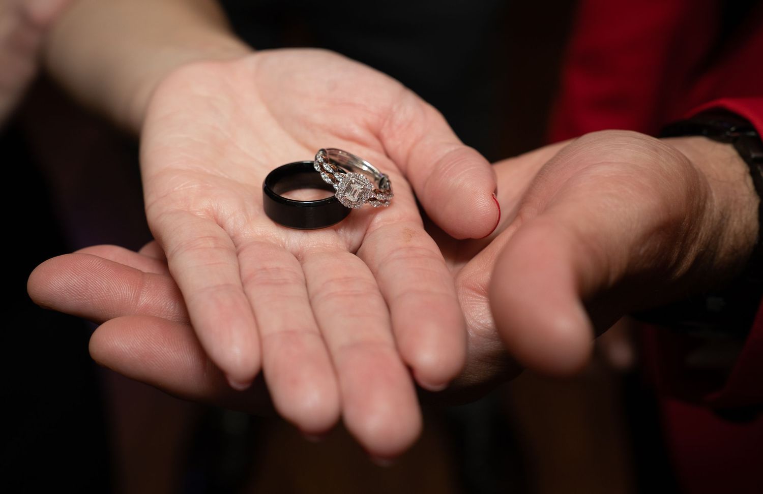 Close-up of hands during a romantic proposal moment at an event.