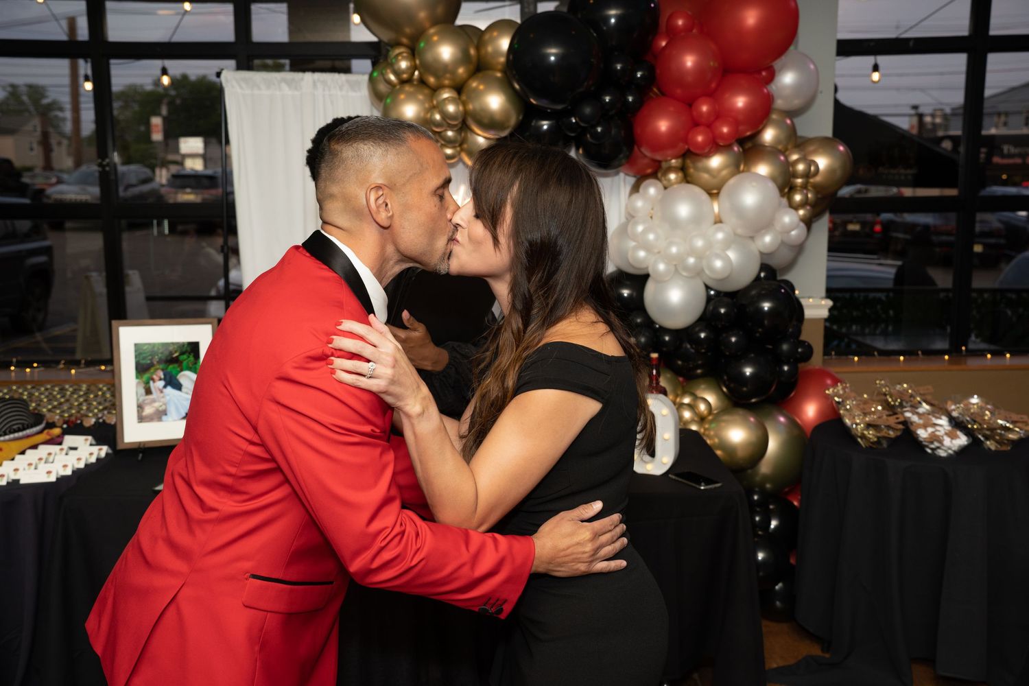 A romantic dance moment captured at a party decorated with festive balloons.