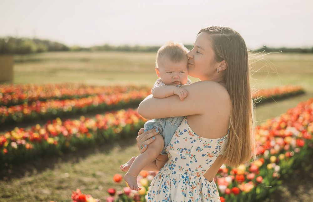 mom kissing her baby in a field of flowers photo by Beryl Photography Winchester VA photographer
