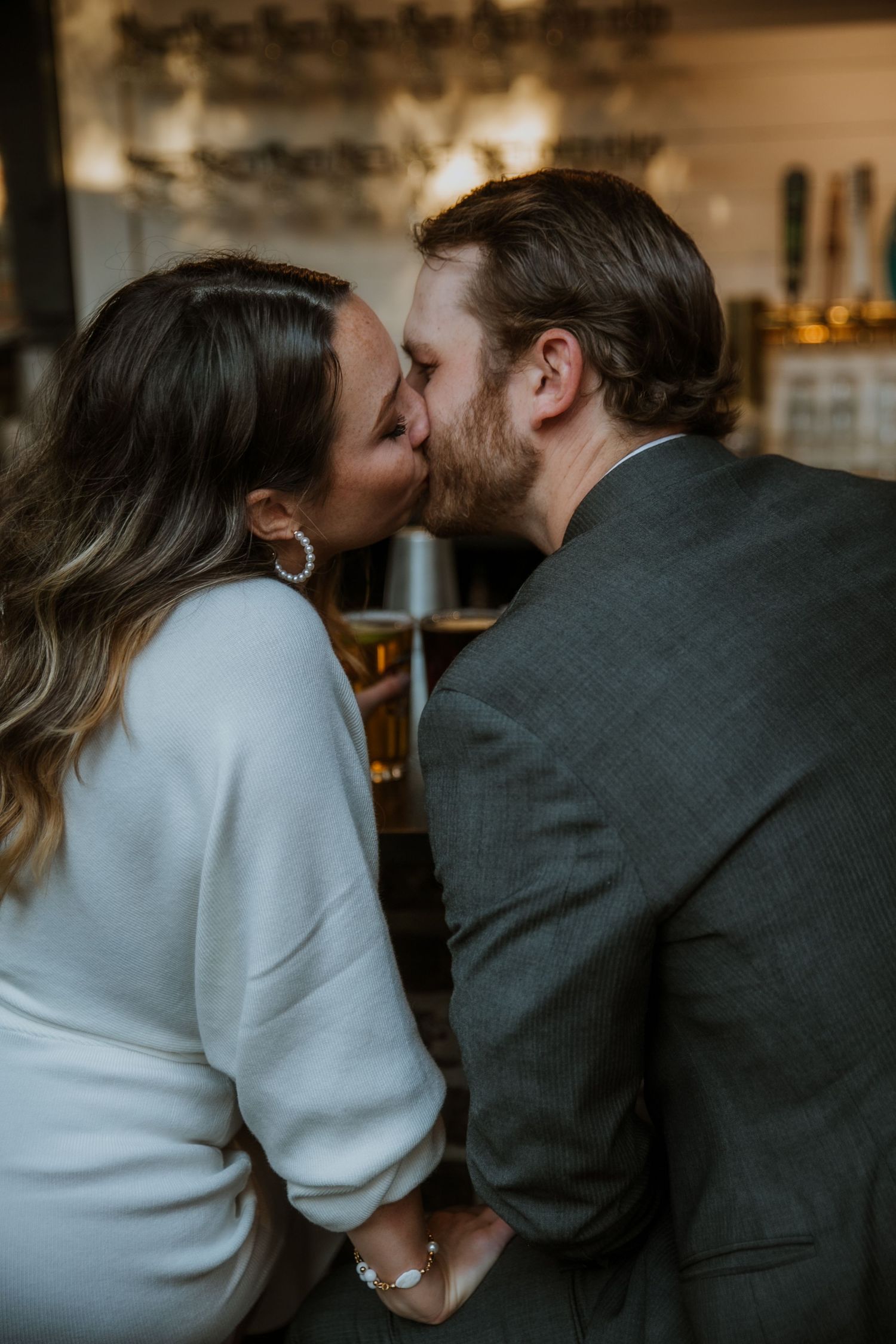 A couple shares a kiss at a bar