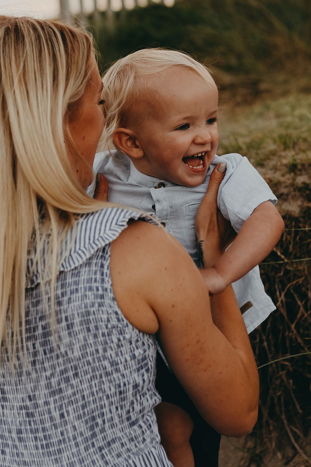 A joyful moment captured between parent and child against a natural backdrop.