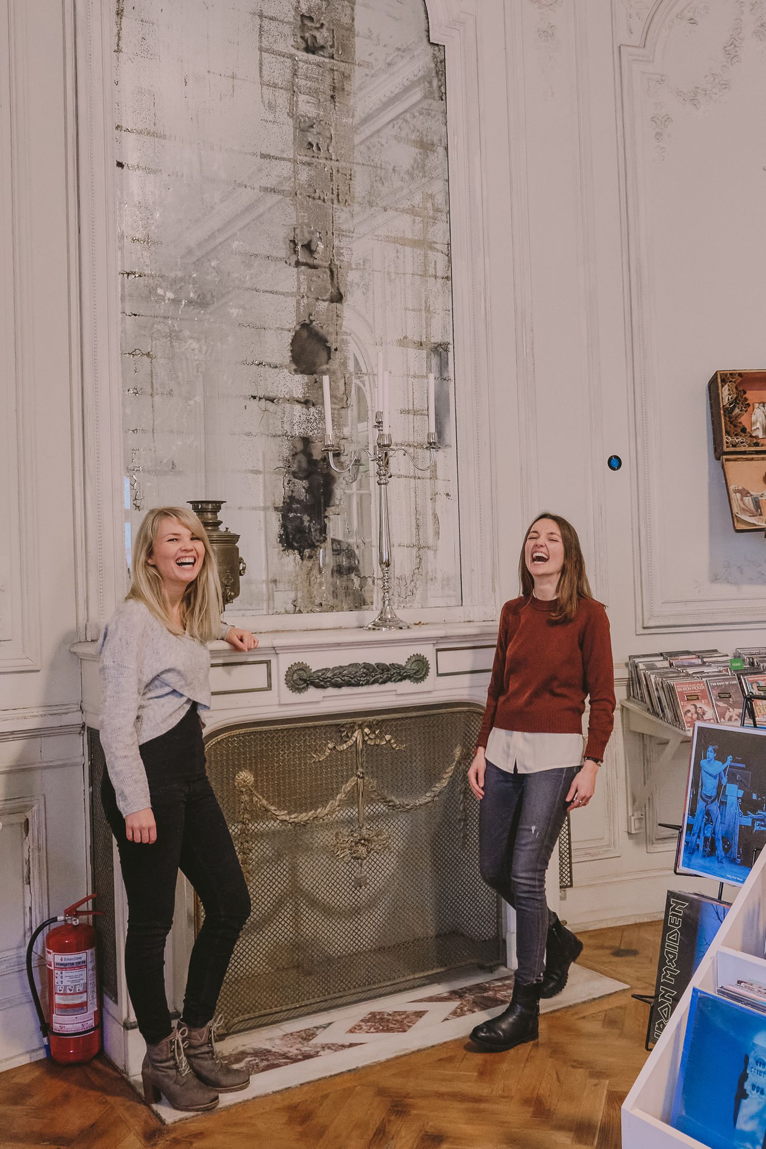 Casual indoor photoshoot with laughter and movement against white walls.