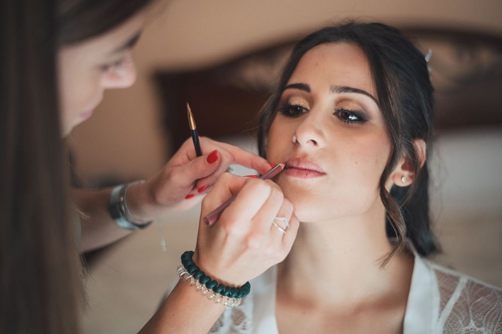 A close-up shot of professional makeup application during wedding preparations.