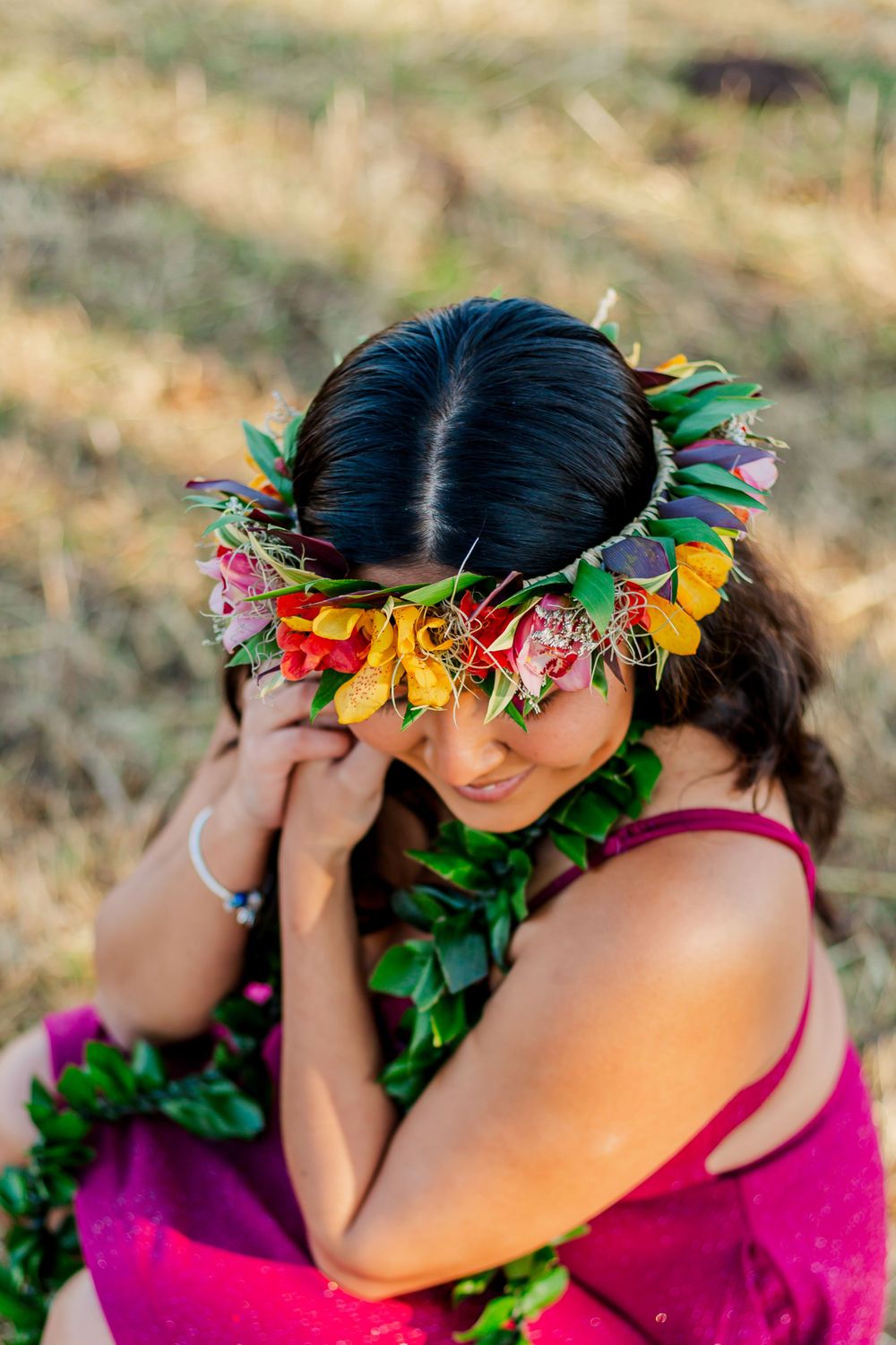 Close-up portrait with colorful flower crown and magenta dress in golden afternoon light.