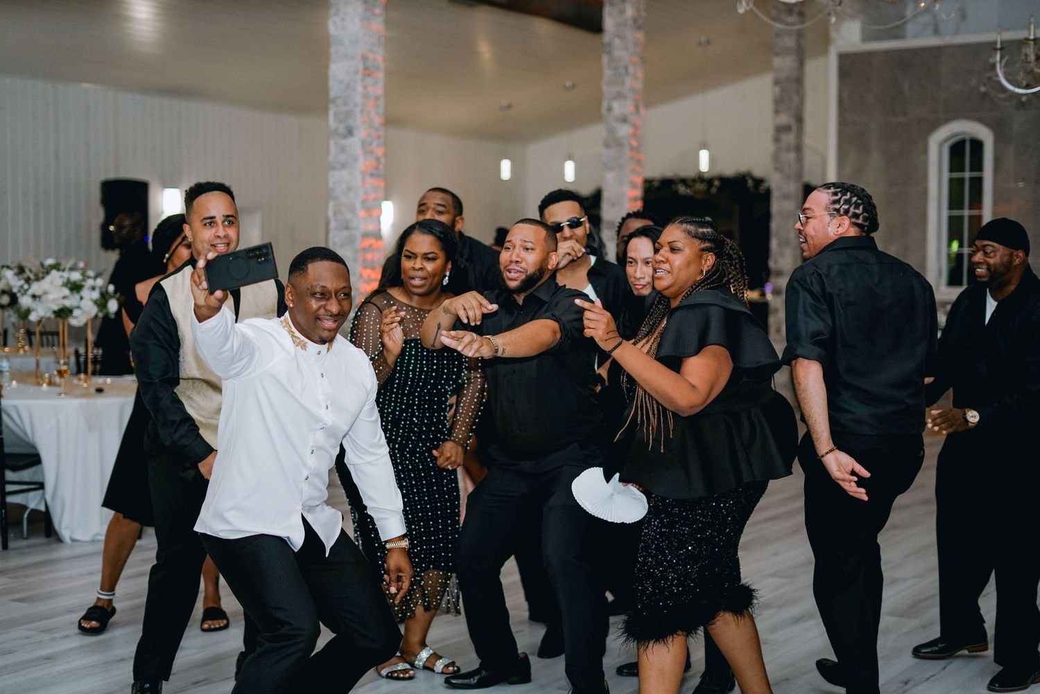 a group of family and friends dancing, laughing, and taking a selfie at a party