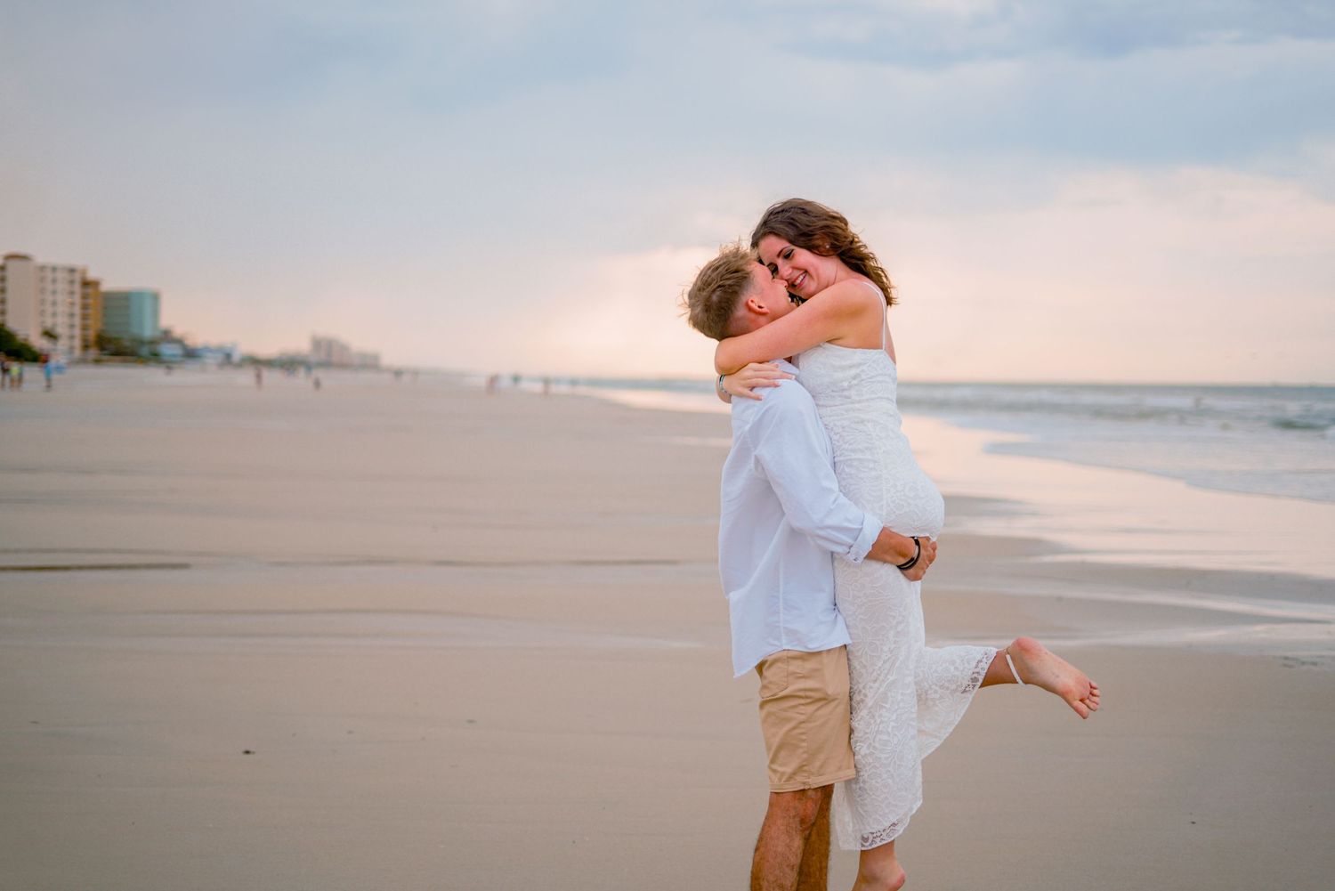 romantic, unique, professional image of a couple dancing and kissing on the beach at sunset
